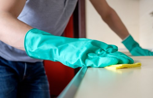 Safe home oven cleaning process using baking soda and gloves